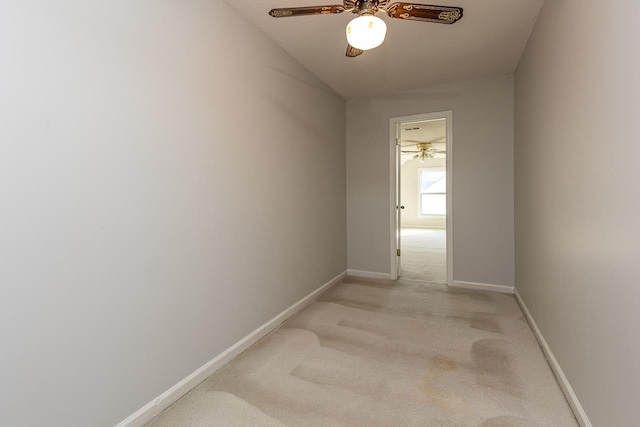 hallway featuring light colored carpet and baseboards