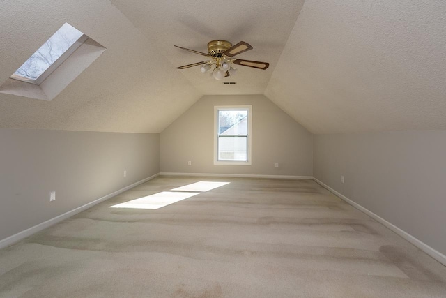 additional living space with baseboards, a textured ceiling, carpet, and vaulted ceiling