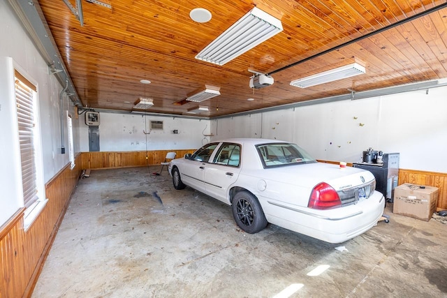 garage featuring wooden walls, wooden ceiling, and a garage door opener