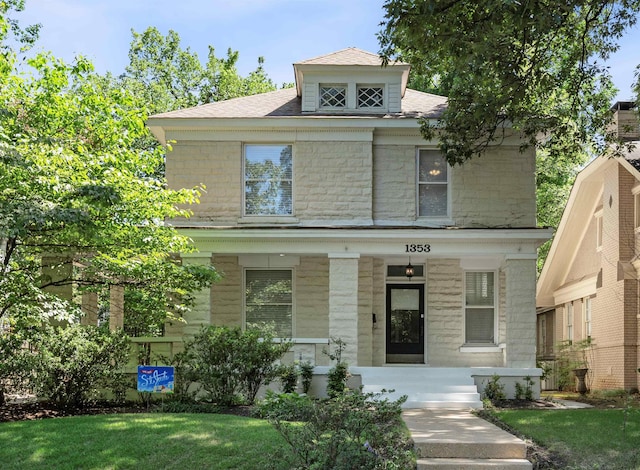 american foursquare style home featuring stone siding and covered porch