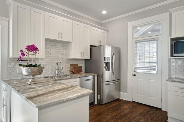 kitchen with crown molding, white cabinets, appliances with stainless steel finishes, and a sink