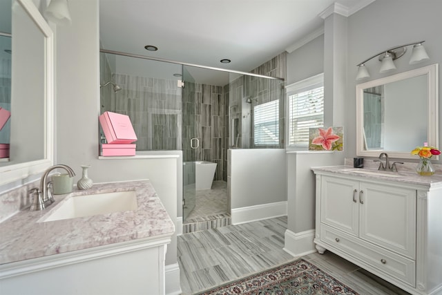 full bath with a sink, a freestanding tub, two vanities, and a shower stall