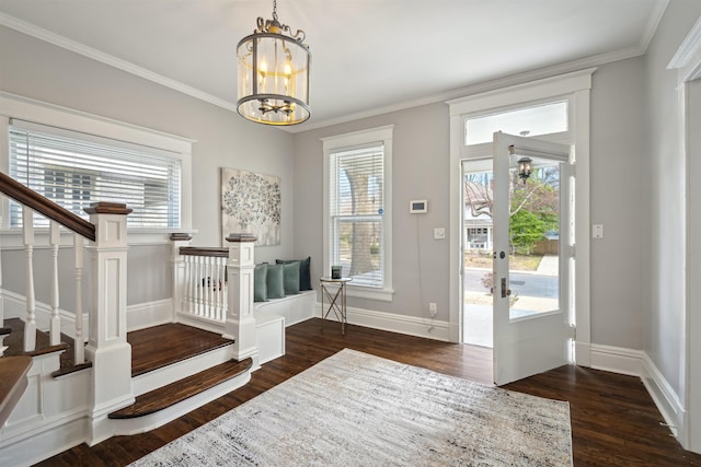 entryway with stairway, crown molding, baseboards, a chandelier, and dark wood-style flooring