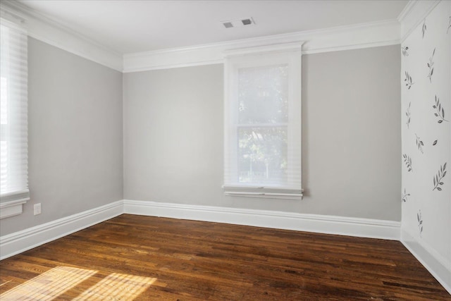 unfurnished room featuring visible vents, ornamental molding, baseboards, and wood finished floors