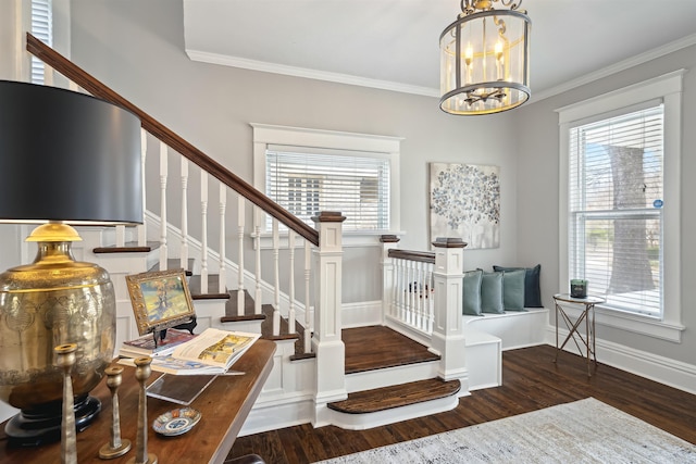 staircase featuring an inviting chandelier, wood finished floors, baseboards, and ornamental molding