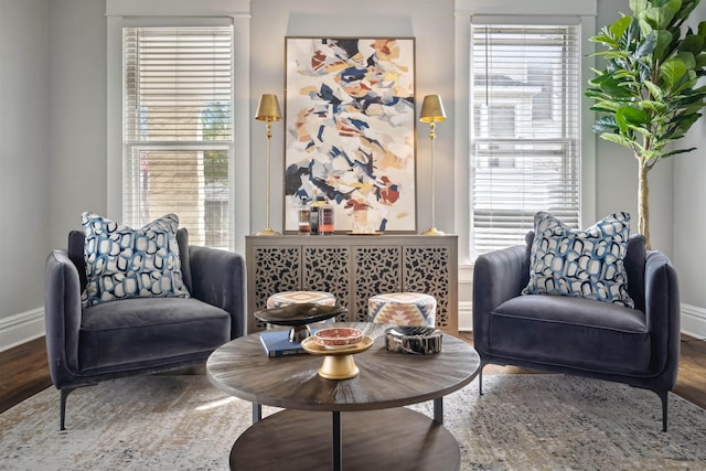 sitting room with plenty of natural light, wood finished floors, and baseboards