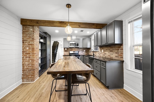 kitchen with a sink, light wood-type flooring, appliances with stainless steel finishes, and gray cabinetry