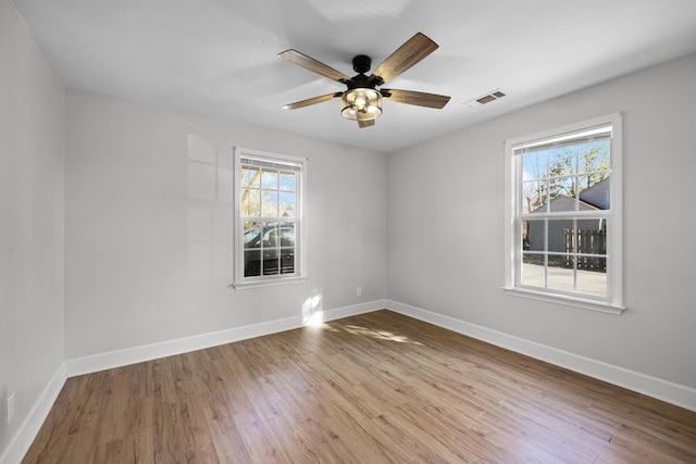 spare room featuring baseboards and wood finished floors