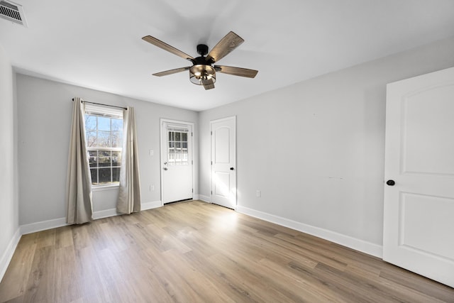 interior space with visible vents, light wood-style flooring, baseboards, and ceiling fan