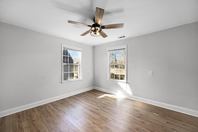 unfurnished room featuring visible vents, ceiling fan, baseboards, and wood finished floors