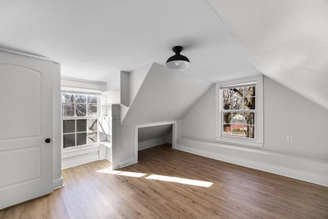 bonus room with lofted ceiling and wood finished floors