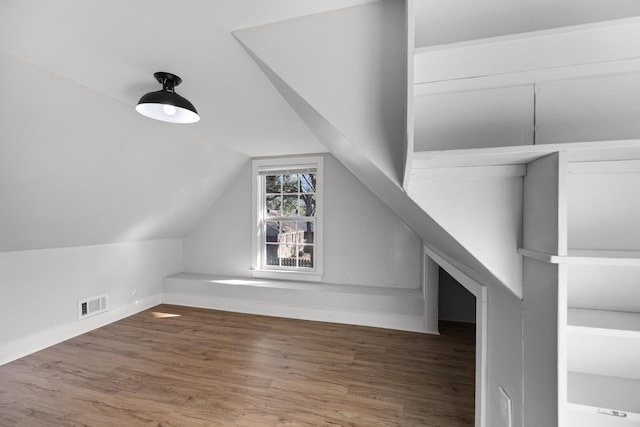 bonus room with visible vents, baseboards, wood finished floors, and vaulted ceiling