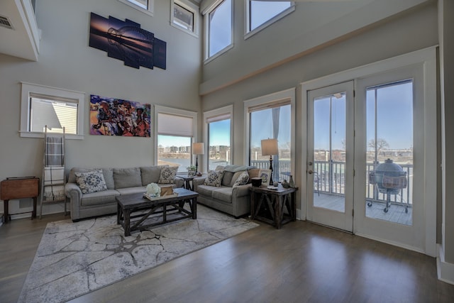 living room with visible vents, a high ceiling, and wood finished floors