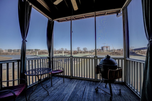 sunroom featuring a city view and ceiling fan