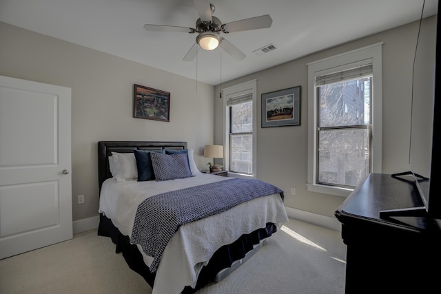 carpeted bedroom with a ceiling fan, visible vents, and baseboards