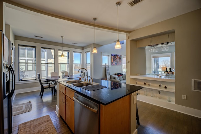 kitchen featuring brown cabinetry, visible vents, a sink, dishwasher, and black fridge