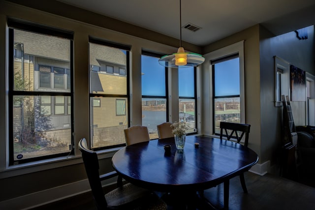 dining space featuring dark wood finished floors, baseboards, and visible vents