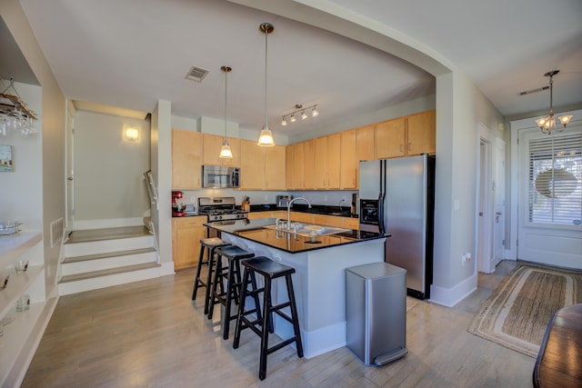 kitchen with visible vents, a sink, light brown cabinetry, stainless steel appliances, and dark countertops