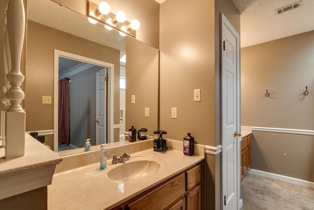 bathroom featuring visible vents, baseboards, a textured ceiling, and vanity