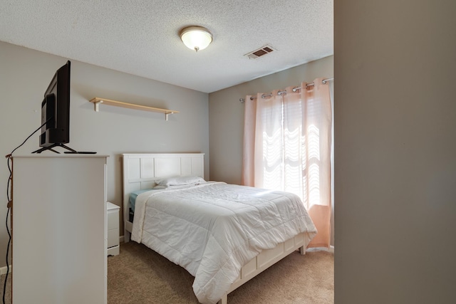 carpeted bedroom with visible vents and a textured ceiling