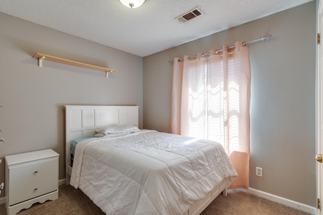 bedroom featuring visible vents, baseboards, a textured ceiling, and carpet flooring