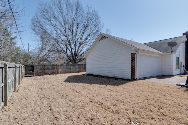 view of side of property featuring brick siding, an attached garage, a chimney, and fence