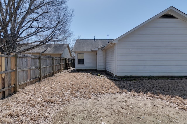 back of house with fence and a shingled roof