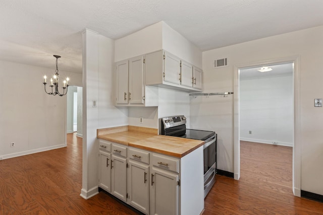 kitchen featuring wood counters, stainless steel electric range, dark wood-type flooring, and an inviting chandelier