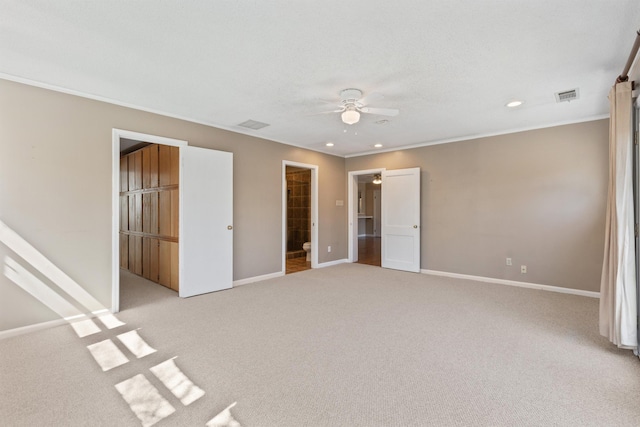 unfurnished bedroom featuring light colored carpet, baseboards, visible vents, and ornamental molding