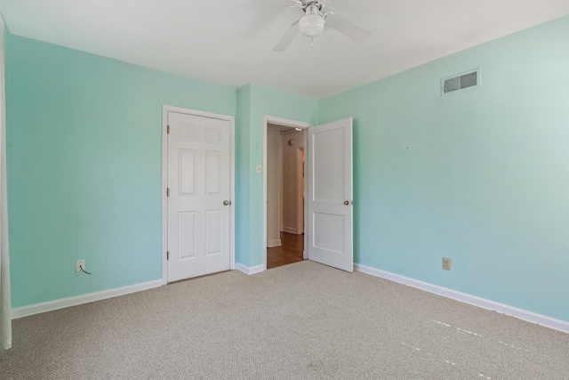 unfurnished bedroom with carpet flooring, baseboards, visible vents, and ceiling fan