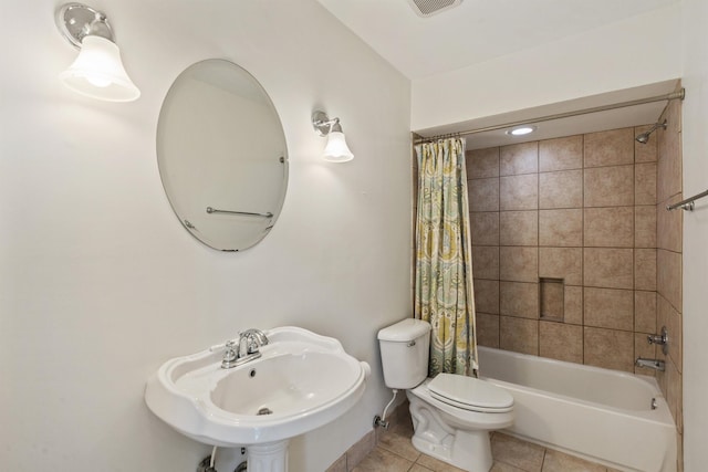 full bathroom featuring a sink, shower / bath combo with shower curtain, toilet, and tile patterned floors