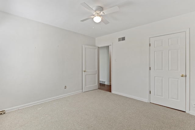 unfurnished bedroom featuring carpet flooring, baseboards, visible vents, and ceiling fan