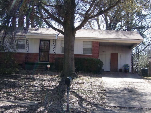 ranch-style house with an attached carport, concrete driveway, brick siding, and crawl space