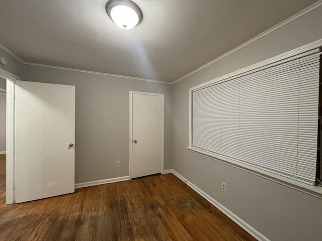 unfurnished bedroom with crown molding, baseboards, and wood finished floors