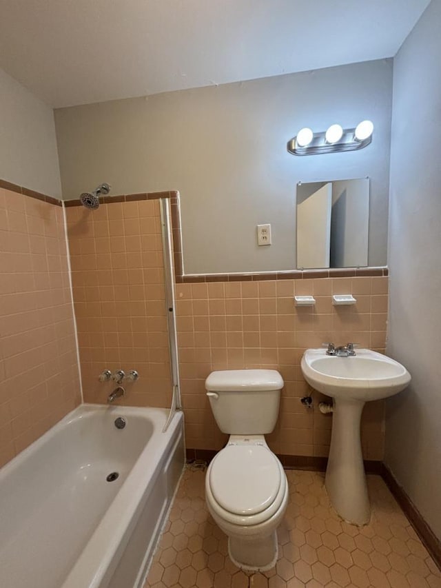 full bathroom with a wainscoted wall, shower / bathing tub combination, a sink, tile walls, and toilet