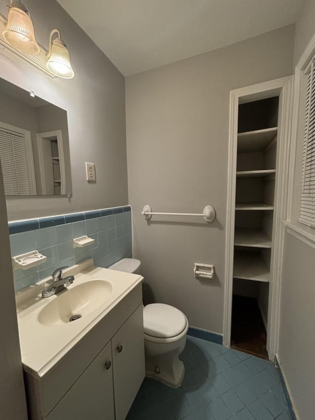 bathroom with tile patterned floors, a closet, toilet, and vanity