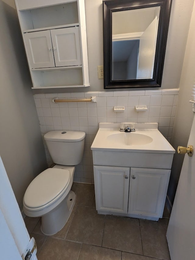 bathroom with a wainscoted wall, toilet, vanity, and tile patterned flooring