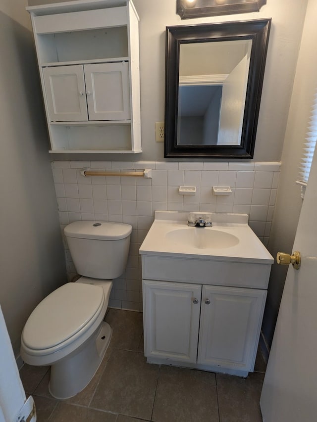 half bathroom featuring vanity, toilet, a wainscoted wall, and tile patterned flooring