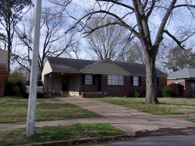 view of front of home featuring crawl space, driveway, a front lawn, and brick siding