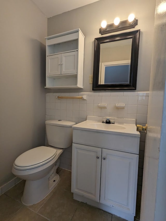 bathroom with toilet, tile walls, vanity, and tile patterned flooring