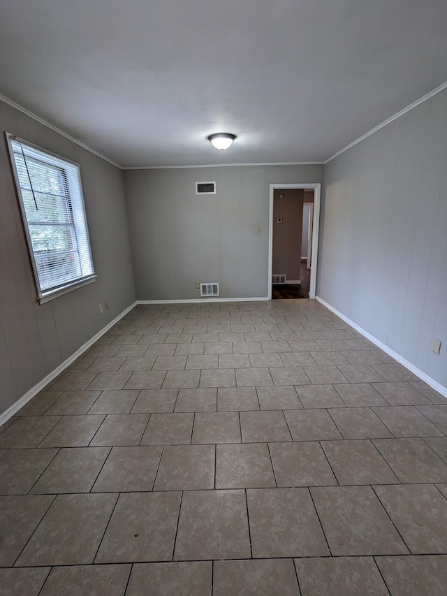 spare room with tile patterned floors, crown molding, and visible vents