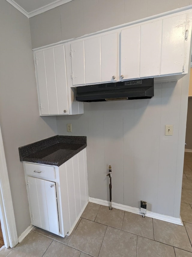 laundry area featuring crown molding and light tile patterned floors