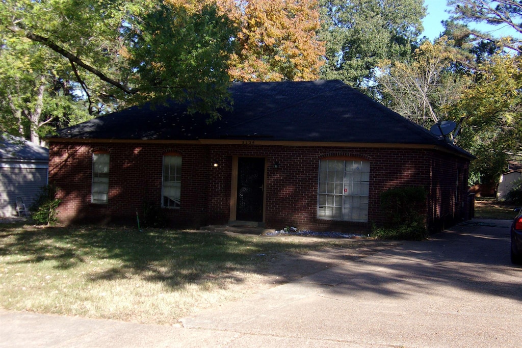 view of front of house with brick siding and a front lawn