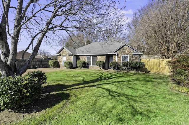 ranch-style home with a front yard, fence, and brick siding