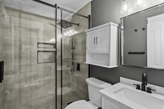 bathroom featuring vanity, toilet, a stall shower, and a textured ceiling