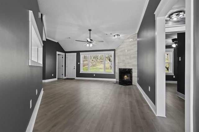 unfurnished living room featuring wood finished floors, plenty of natural light, a ceiling fan, and a premium fireplace