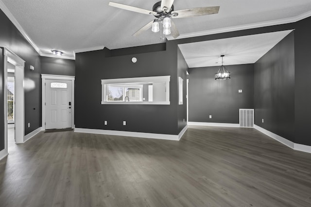 unfurnished living room featuring visible vents, baseboards, wood finished floors, and crown molding