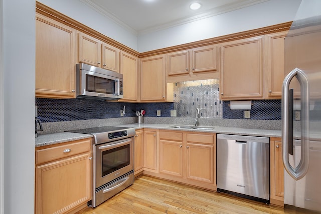 kitchen featuring backsplash, ornamental molding, light wood-style flooring, stainless steel appliances, and a sink