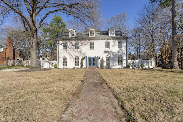 view of front facade with french doors, a front yard, and fence