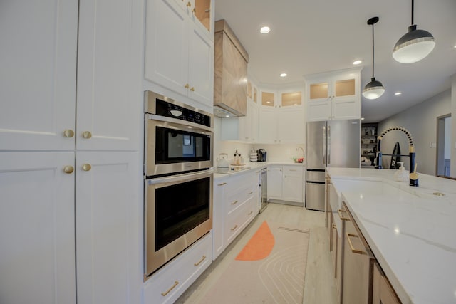 kitchen featuring glass insert cabinets, light stone countertops, recessed lighting, appliances with stainless steel finishes, and white cabinetry